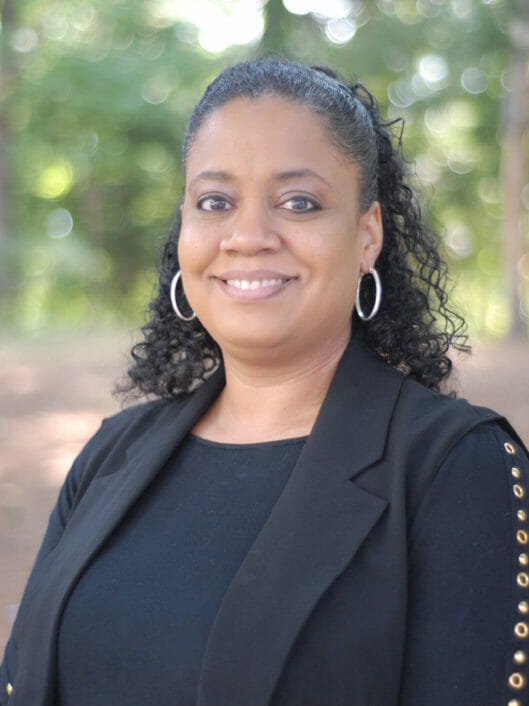 Robin Speller, Executive Support Manager at McLean School, smiles at camera while outside
