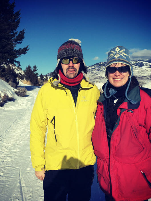 Christopher Childs, STEM Teacher at McLean School, poses for picture on a snowy hill in a yellow winter coat